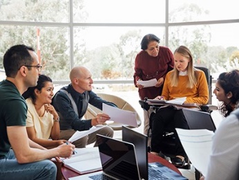 A group of people having a meeting together. 