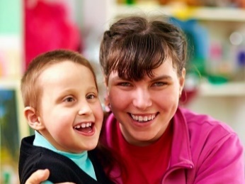 A woman hugging a young boy. 