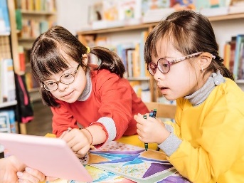 Two girls looking at an iPad together. 