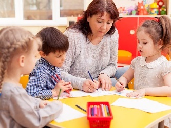 A teacher helping children with their work.