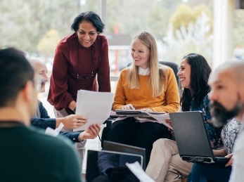 A group of people talking about a document.