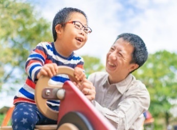 A man playing with his son at a playground.