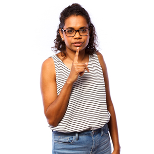 A woman with a finger on her lips in a 'shh' gesture.