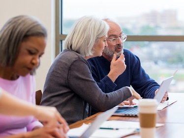 Two people looking at a document together. 
