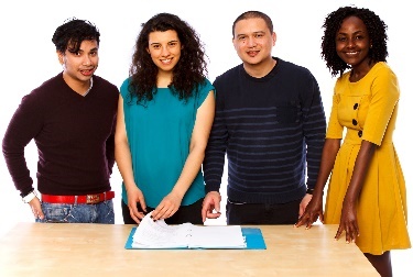 A group of people looking at a document. 