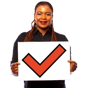 A person holding up a piece of paper with a tick on it. 