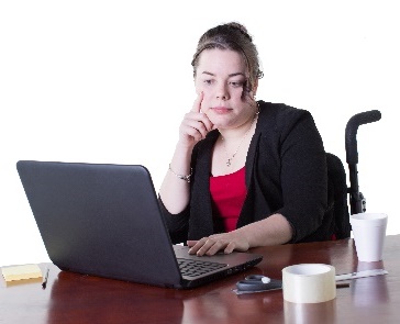A person in a wheelchair using a laptop. 