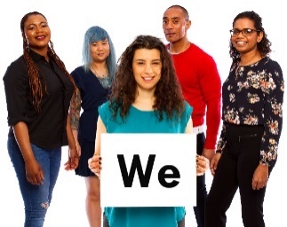 A group of people, with a person at the front holding a sign saying 'We'.