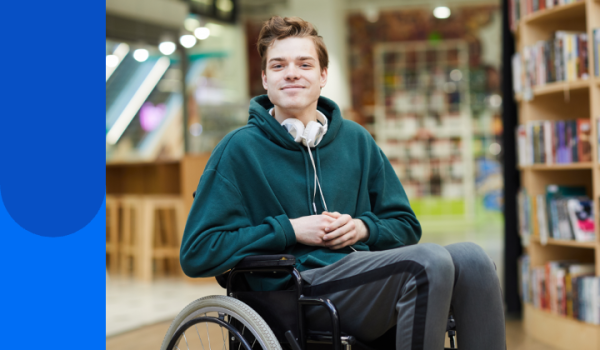 Young man sitting in a wheelchair in a library or bookshop