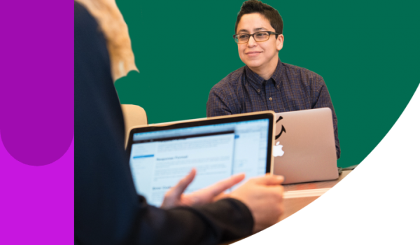 A person in a meeting with glasses and a laptop