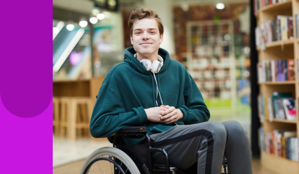 Image of young person sitting in a wheelchair in a library