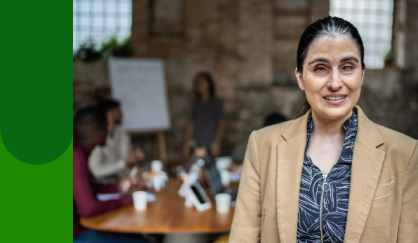 Image of women standing in front of people sitting around a table